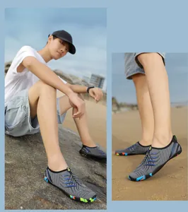 Dettaglio scarpe da scoglio grigie ad asciugatura rapida su spiaggia rocciosa e sabbia