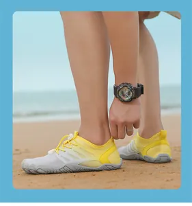 Detalle de zapatos de agua amarillo y gris con suela de goma antideslizante en la playa