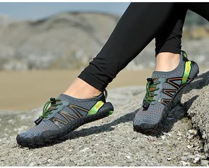Détail de chaussures d'eau grises avec accents verts et laçage rapide sur rocher