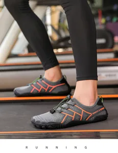 Dettaglio di scarpe da acqua grigie ad asciugatura rapida con dettagli arancioni sul tapis