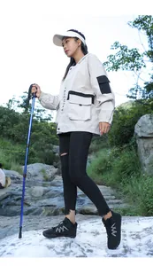 Détail d'équipement de randonnée avec bottes hautes et bâtons dans un ruisseau de montagne