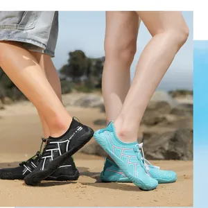Scarpe acquatiche ad asciugatura rapida in nero e verde menta sulla spiaggia sabbiosa