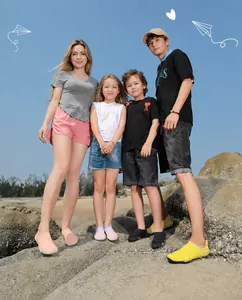Famille portant des chaussures d'eau à séchage rapide sur plage avec semelles en caoutchouc