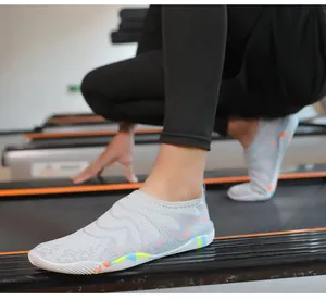 Détail d'une chaussure de randonnée grise respirante avec motif à vagues orange au gym