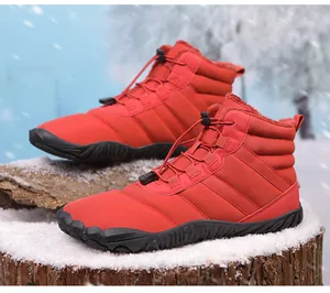 Detail of red waterproof snow boots with warm fur lining on snow covered wood pile