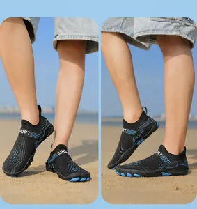 Detail of black water shoes with blue grip soles and sport straps on a beach setting