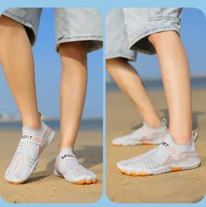 Outdoor water shoes with breathable mesh upper and orange anti-slip sole on the beach