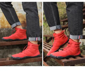 Close-up of red waterproof outdoor snow boots with non-slip rubber soles on stairs