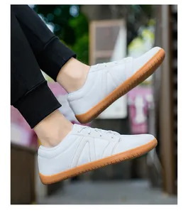 Détail de baskets blanches en flyknit avec bout large et semelle en gomme marron porté