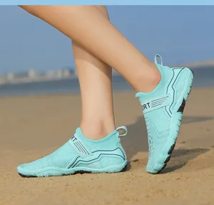 Detail of mint green breathable mesh water shoes with anti-slip sole on a sunny beach