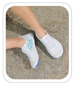 Detail of white mesh water shoes with blue accents on a natural stone surface