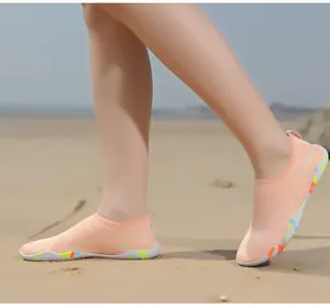 Gros plan de chaussures d'eau en mesh orange avec semelles antidérapantes sur plage