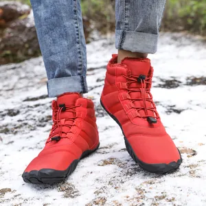 Waterproof red outdoor snow boots with thick faux fur lining on snowy ground