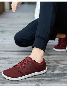 Gros plan de baskets bordeaux respirantes en maille sur un sol en bois gris
