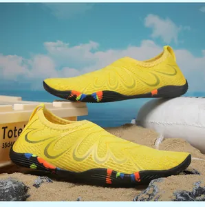 Chaussures d'eau à séchage rapide jaune avec semelle en caoutchouc sur une plage