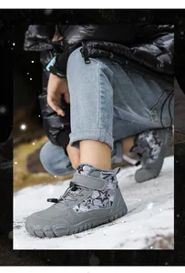 Detail of winter kids snow boots with star pattern and anti-slip sole on snowy ground