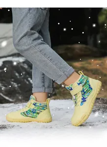 Detail of waterproof kids snow boots with colorful star patterns in a snowy outdoor scene