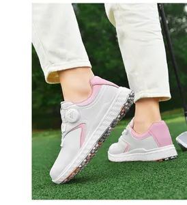 Dettaglio di scarpe da golf rosa e bianche con sistema di lacci BOA su erba