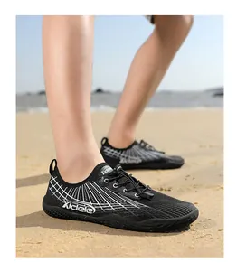 Detail of breathable mesh water shoes with drawstring laces on a sandy beach