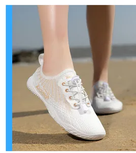 Close-up of white breathable water shoes with orange accents and quick-lace elastic cords