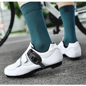 Detail von weißen Radschuhen mit Drehverschluss und türkisen Socken auf Asphalt