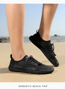 Close-up of breathable black water shoes with anti-slip rubber soles on a sandy beach