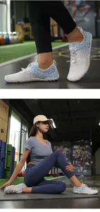 Close-up view of white water shoes with blue scale patterns and mesh fabric on a person