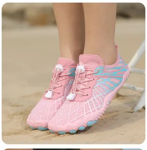 Primer plano de zapatos de agua en malla rosa con cordones rápidos sobre arena de playa