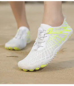 Detalle de zapatos de agua blancos transpirables con cordones en playa de arena