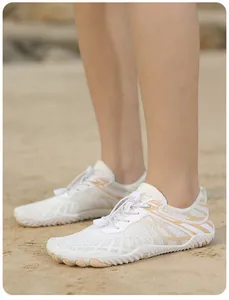Zapatos acuáticos de malla blanca con sistema de cordones rápidos en la playa