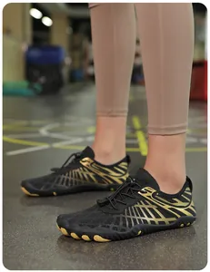 Detalle de zapato minimalista con acentos dorados y suela de goma antideslizante en gimnasio