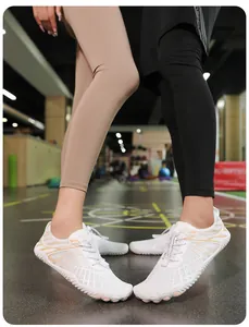 Detalle de calzado minimalista de malla blanca con rayas naranjas y suela de goma