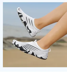 Action shot of white breathable water shoes with anti-slip rubber soles on beach sand