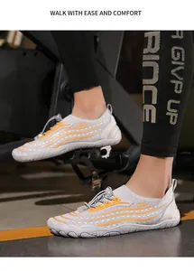 Dettaglio di scarpe acquatiche grigie con motivi arancioni e sistema di allacciatura rapida