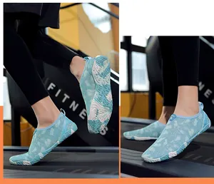 Detail van lichtblauwe waterschoenen met bloemenprint en antislip rubberen zool