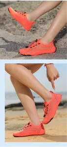 Dettaglio scarpe da scoglio arancioni con suola in gomma antiscivolo e lacci a coulisse