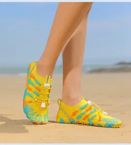 Detalle de zapatos de agua amarillos con cordones elásticos en una playa soleada