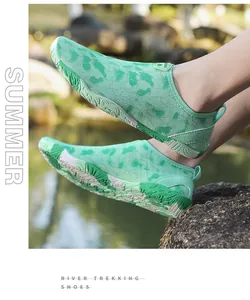 Detail van groene camouflage trekkingschoenen met antislip rubberen zolen op rotsen