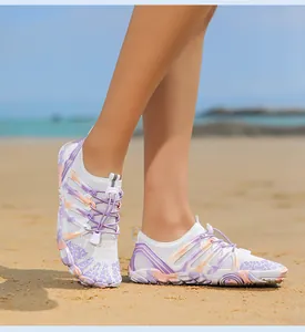 Detalle de zapatos de playa blancos con patrones tie-dye morados y cordones elásticos