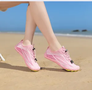 Close-up of pink quick-dry water shoes with non-slip sole on a sandy beach