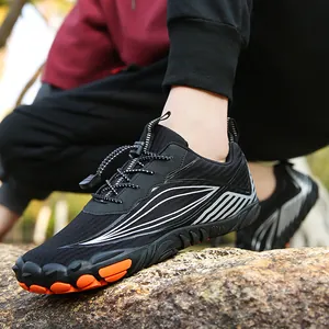 Outdoor non-slip hiking shoes in black with orange accents on thick rubber soles