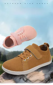 Detail view of pink and yellow wide-toe barefoot sneakers with breathable mesh and velcro