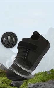 Close-up of breathable mesh fabric and suede panels on black kids outdoor sneakers