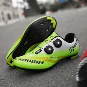 Scarpe da ciclismo verde neon e bianco con doppia manopola su terreno in asfalto
