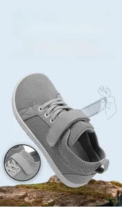 Detail showing the adjustable hook and loop closure on grey breathable kids sneakers