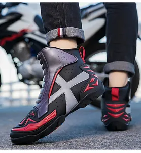 Detalle de botas de moto de caña alta con protectores rojos y suelas antideslizantes