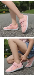 Close-up of pink breathable mesh kids barefoot shoes with velcro straps in outdoor park