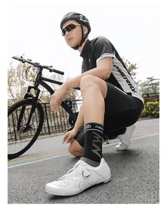 Detail of white road bike shoes with BOA dial system and breathable perforations