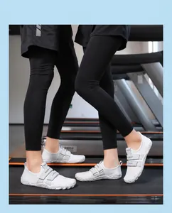 Detalle de zapatos deportivos blancos con cierre de velcro en un entorno de gimnasio