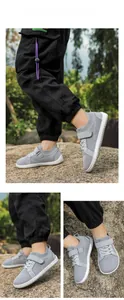 Detail of grey breathable mesh kids barefoot shoes with velcro and anti-slip white soles